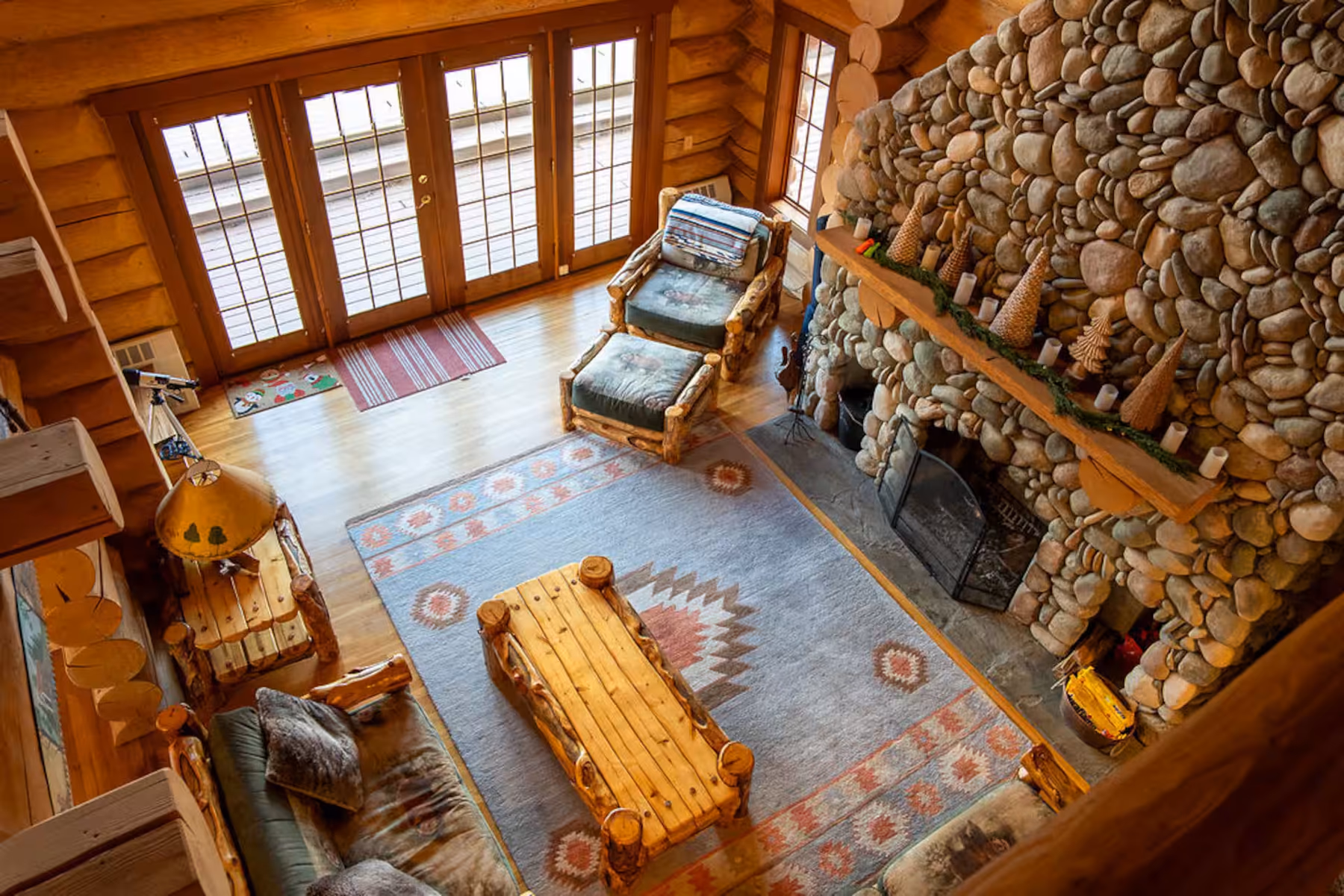 Log cabin living room with a stone fireplace